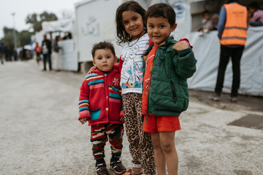 3 small Children smiling in Camp Moira