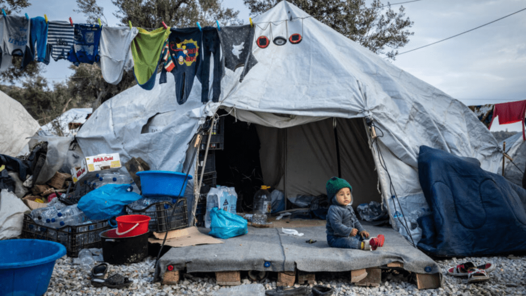 Child sitting in front of tent in Greece
